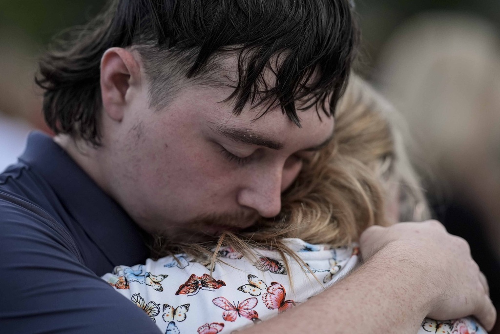 Mourners pray during a candlelight vigil for the slain students and teachers at Apalachee High School