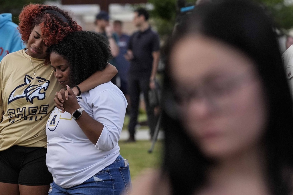 Mourners pray during a candlelight vigil for the slain students and teachers at Apalachee High School