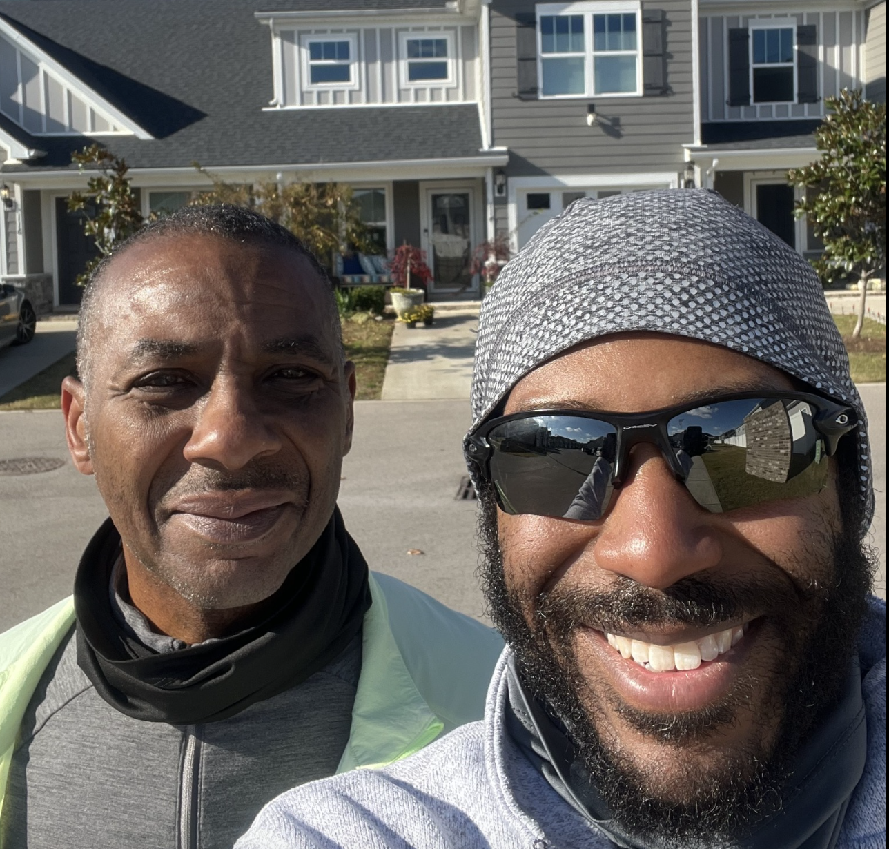 Two men in front of a house